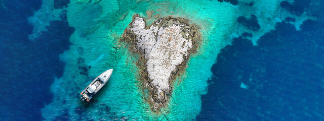 Aerial drone ultra wide photo of secluded heart shaped island with turquoise sea in Caribbean...