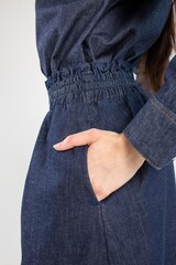 Blue denim skirt with elastic waistband, side pockets, white background