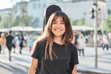 portrait of young beautiful woman outdoor with her guitar gig bag, model is Latin American Ethnic...