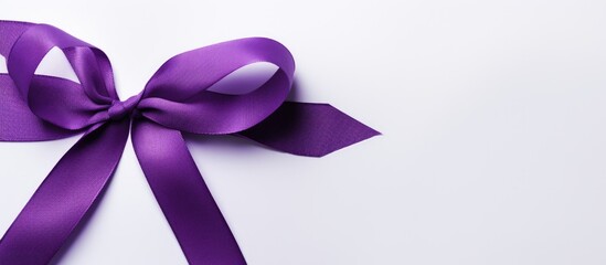 A purple ribbon, symbolizing Alzheimers and domestic violence awareness, is placed on a white background. The ribbon stands out against the clean white backdrop.