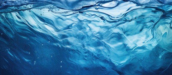 This close-up view captures the transparent dark blue clear water surface with ripples and splashes. The abstract summer banner background showcases water waves with copy space,