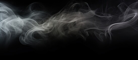 Obraz premium A black and white picture showing abstract smoke creating a textured frame on a dark black background. The swirling patterns of the smoke give a mysterious atmosphere.