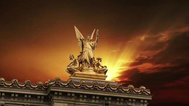 Golden statue of Liberty on the roof of the Opera Garnier (Garnier Palace)  against the background of the sunset. Sculpted by Charles Gumery in 1869. Paris, France. 4K, time lapse  