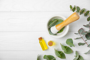 Eucalyptus leaves and mortar on a wooden background.Spa concept.Ingredients for alternative medicine and natural cosmetics. A bottle of essential oil and a bunch of eucalyptus. Organic skin care 