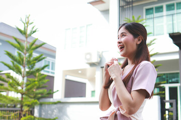 Portrait of a beautiful Asian woman moving into a new house. She smiles happily. Real estate business concepts. House for sale. copy space