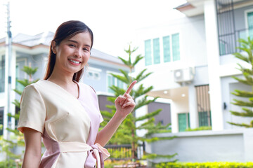 Portrait of a beautiful Asian woman moving into a new house. She smiles happily. Real estate business concepts. House for sale. copy space