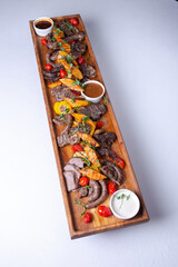 Top view Rustic wooden platter with assorted meats and vegetables