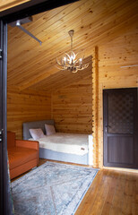 Fototapeta na wymiar Rustic wooden cabin interior with bed, sofa, and armoire