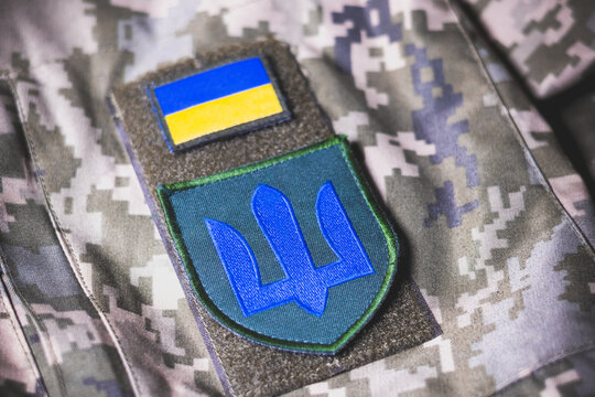 Close up view of.the state coat of arms of Ukraine..Armed Forces of Ukraine. Ukrainian army. Ukrainian flag on military uniform.