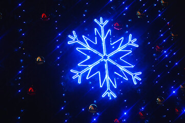 Beautiful large blue decorative shiny glowing snowflake on a dark background. Evening festive...