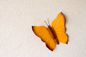 Butterfly ornament made of metal pinned to the wall