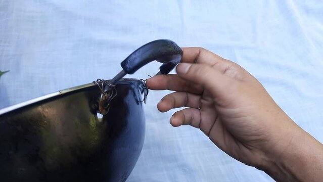 A frying pan handle tied with wire. Broken kitchen equipment. Low quality product