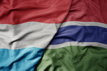 big waving national colorful flag of gambia and national flag of luxembourg .