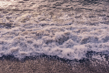 Sea waves near the coast at sunset. - 745995119