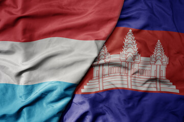big waving national colorful flag of cambodia and national flag of luxembourg .
