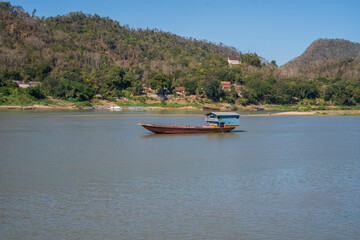 Fototapeta na wymiar Laotian wooden boats on the Mekong River in Luang Prabang in Laos Southeast Asia