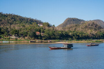 Obraz premium Laotian wooden boats on the Mekong River in Luang Prabang in Laos Southeast Asia