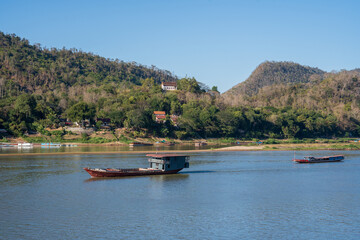Laotian wooden boats on the Mekong River in Luang Prabang in Laos Southeast Asia
