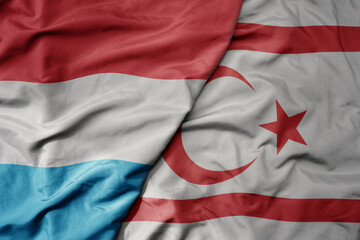 big waving national colorful flag of northern cyprus and national flag of luxembourg .