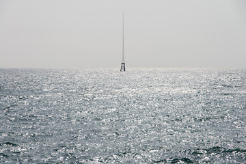 View of the steel tower on the sea horizon