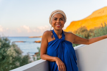 Beautiful woman leaning on the railing of her hotel enjoying the beautiful views of the Aegean Sea...