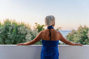 Unrecognizable woman enjoying the views from the terrace of her Aegean Sea Hotel on the south of...