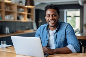 Obraz premium Man at home working on a laptop computer smiling