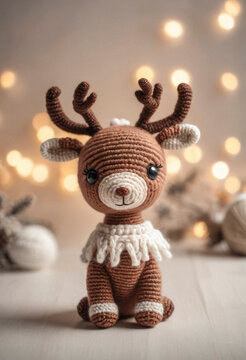 Little cute reindeer handmade toy on beautiful Christmas background. Amigurumi toy making, knitting, hobby