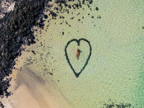 Romantic heart shape on a serene beach from above