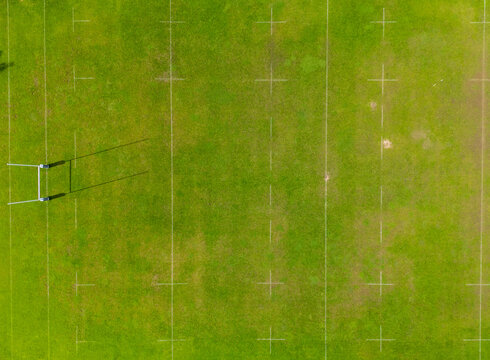Aerial view of a green sports field with white markings