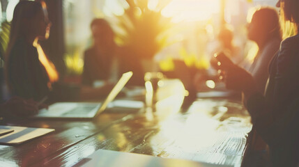 A multicultural team engaged in a round-table discussion, with one member highlighting a point on a laptop screen, business meeting, blurred background, with copy space