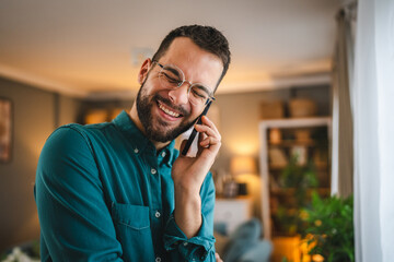 One adult man with eyeglasses stand at home use mobile phone talk