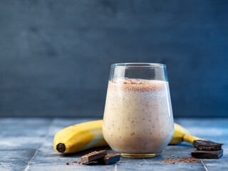 glass of banana smoothie with milk and chocolate, copy space