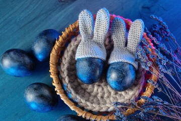 Easter composition. Blue colored eggs with bunny ears in a basket. Easter holiday card . Top view