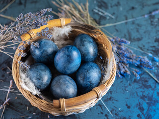 Blue Easter eggs in a basket on the table. Lavender color