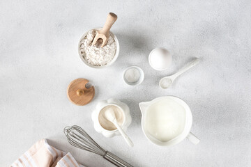 baking ingredients, egg, flour, sugar, milk and kitchen tools on white background with space to copy