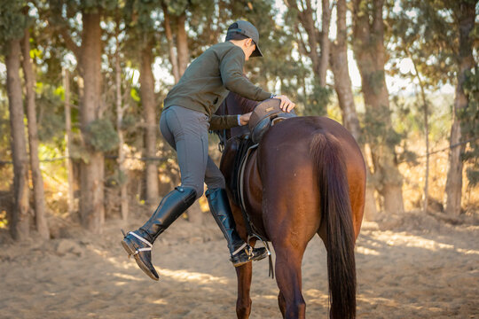 chico joven adolescente con gorra montando a caballo 