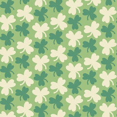 Seamless patttern with big and small white, dark green clovers on green background for wrapping, st Patrick's day, packaging, wallpapers, notebooks, fabrics