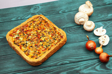 shortbread vegetable freshly baked homemade pie on the blue table. crust baking with mushrooms and vegetables on a wooden texture. shortcrust pastry home baking concept