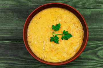 pea soup with a sprig of parsley in a clay plate	