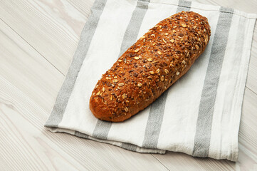 black sliced bread with bran on a white towel. oval dark bread on light texture