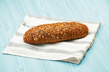 black sliced bread with bran on a white towel. oval dark bread on light texture	