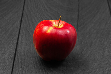 red ripe apple on a dark wooden background.	