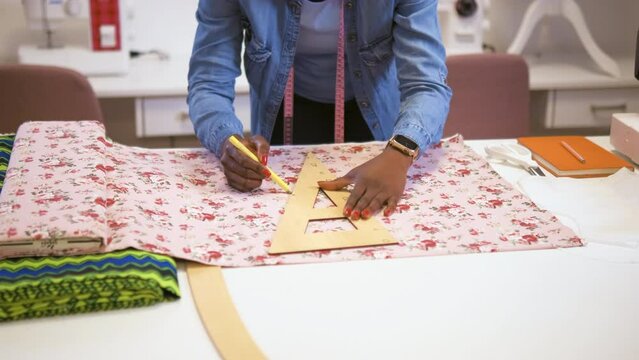 Close up of female fashion trailor working on dress diesign in her workshop.