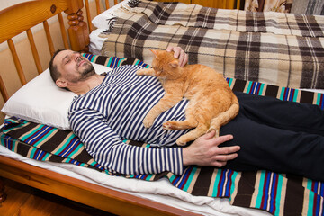 A European man sleeps with a red cat.