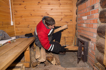 A man lights up the stove in the bathhouse.