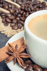 Coffee in cup and roasted dark coffee beans with anise and cinnamon