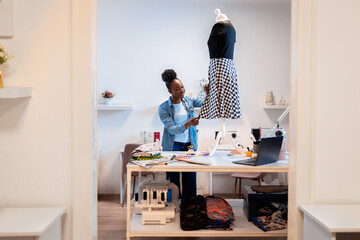 Female fashion tailor working on dress design in her workshop.