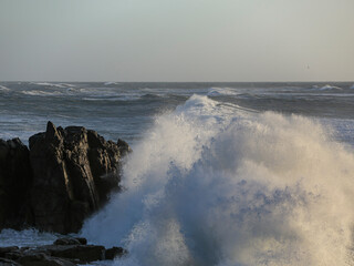 Small cape being hit by strong stormy sea waves