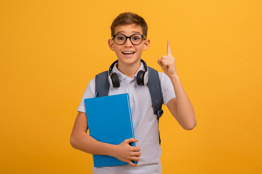 Excited Teen Boy Wearing Eyeglasses Having Idea, Raising Finger Up